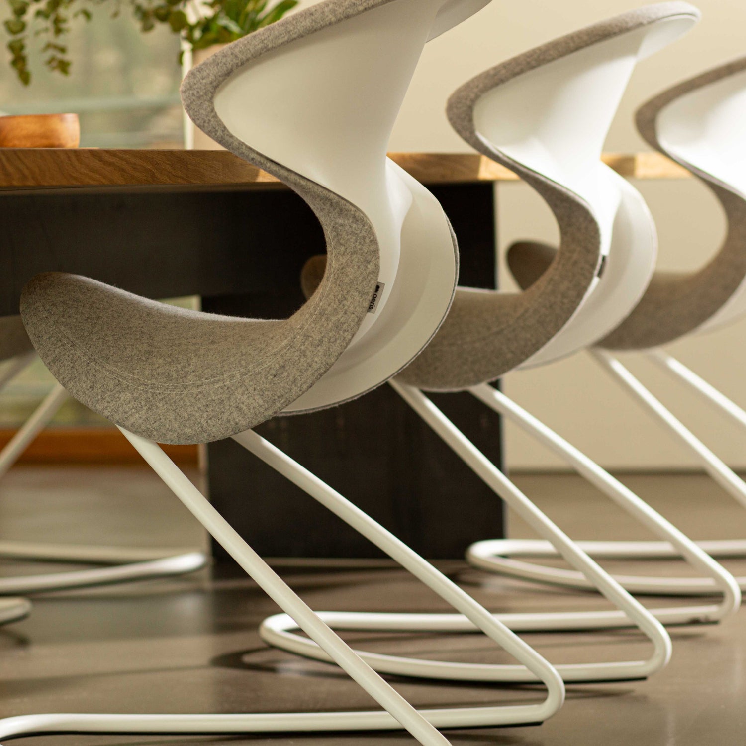 Aeris Oyo schommelstoel in grijs vilt en wit frame aan de eetkamertafel